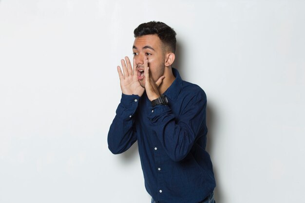 young handsome business man shouting and yelling announcing isolated on white background