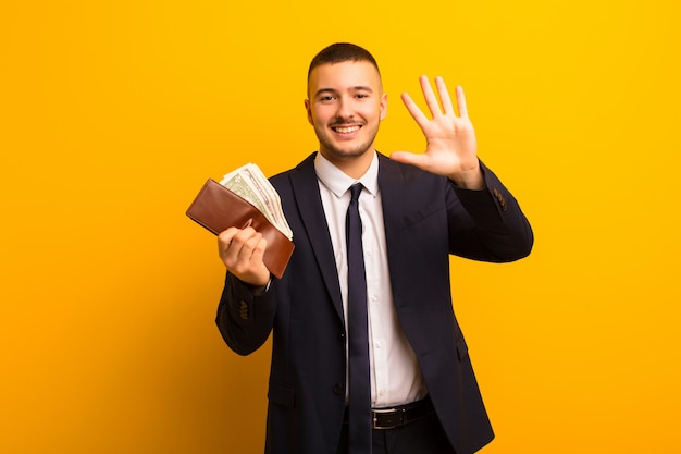 Young handsome businessman  against flat wall money concept