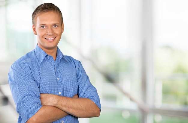 Young handsome businessman on blurred office background