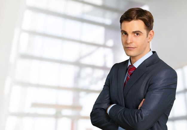 Young handsome businessman on blurred office background