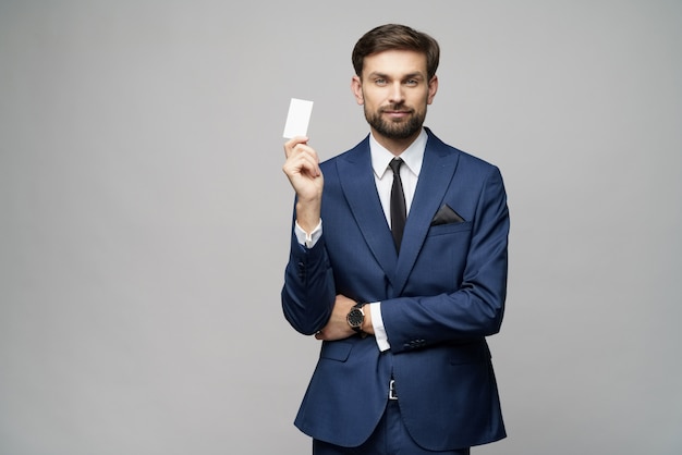 Young handsome businessman holding business or credit card