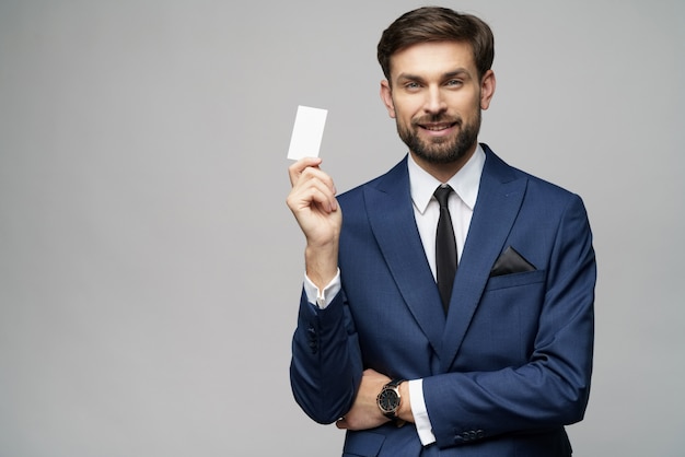 Young handsome businessman holding business or credit card