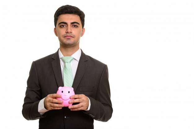 Young handsome businessman holding piggy bank