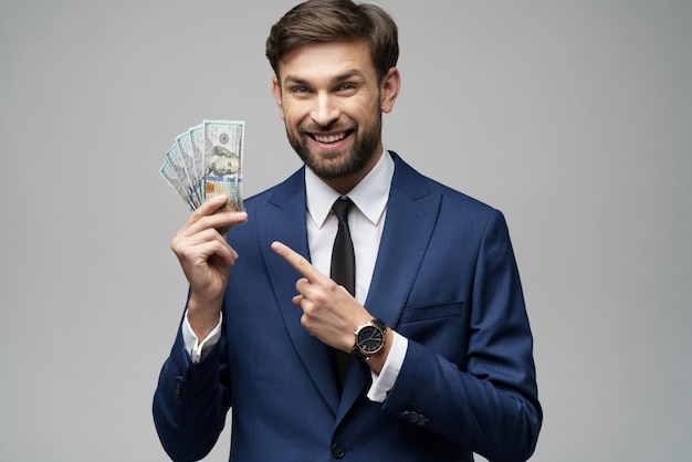 Young handsome businessman holding US dollar bills