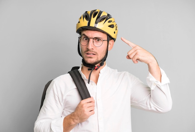写真 自転車のヘルメットで分離された若いハンサムな実業家
