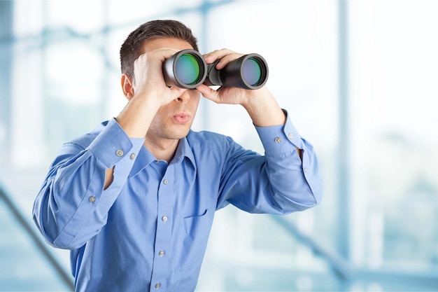 Young handsome Businessman looking in binoculars