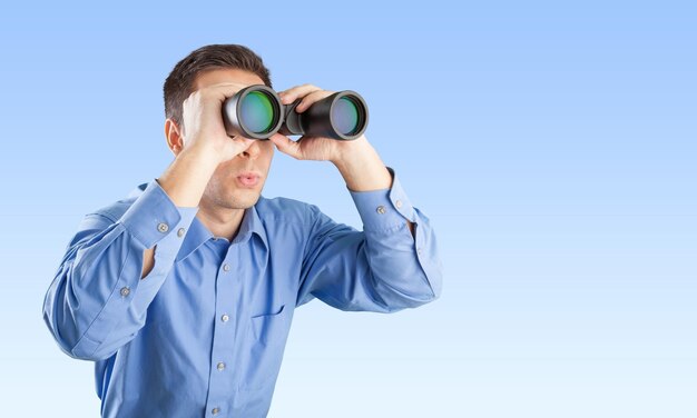 Young handsome Businessman looking in binoculars