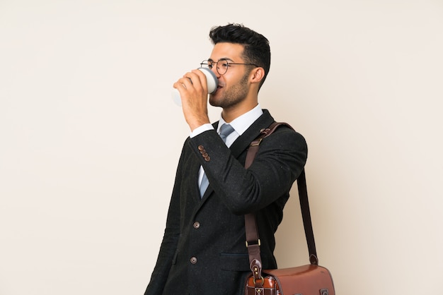 Молодой красивый бизнесмен мужчина держит кофе, чтобы забрать на изолированном фоне