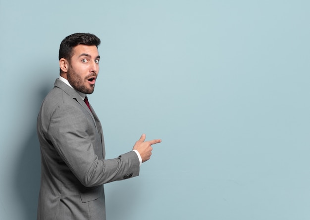 Young handsome businessman pointing or showing an empty place to yout concept