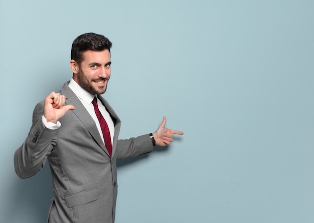 Young handsome businessman pointing or showing an empty place