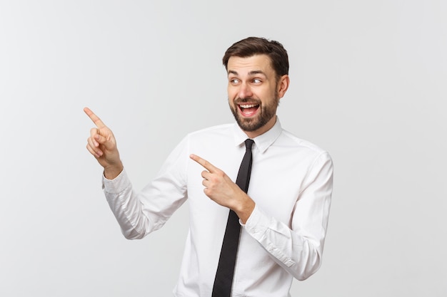 Young handsome businessman pointing to something using a finger.