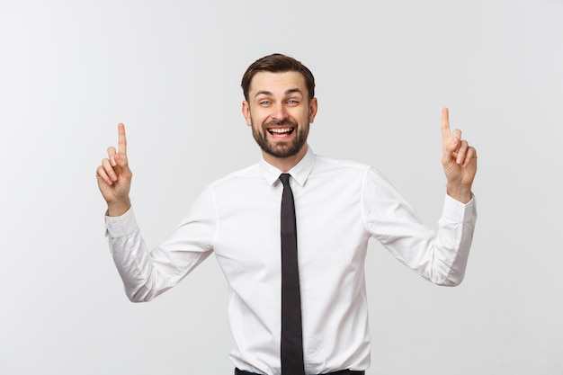 Young handsome businessman pointing to something using a finger.