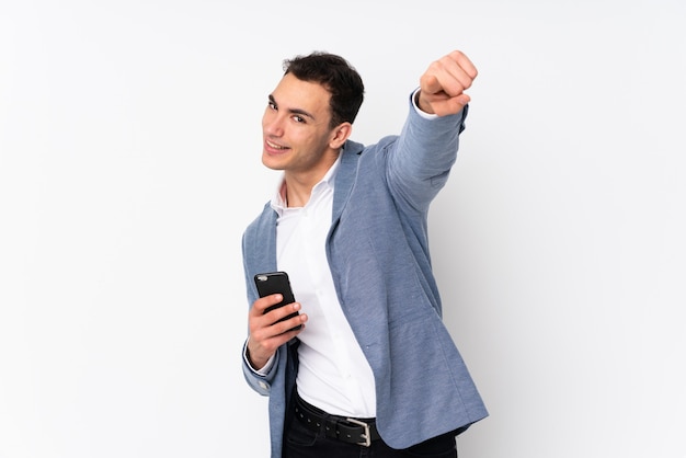 Young handsome businessman on points finger at you while smiling