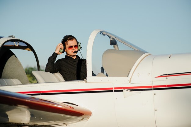 Young handsome businessman standing inside private plane