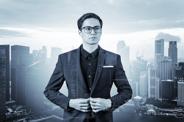 배경 이중 노출 싱가포르에서 MBA 졸업 후 새로운 경력 기회를 꿈꾸는 양복과 안경을 쓴 젊고 잘 생긴 사업가
