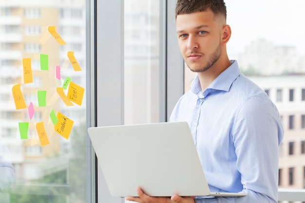 Young handsome businessman using laptop at his office