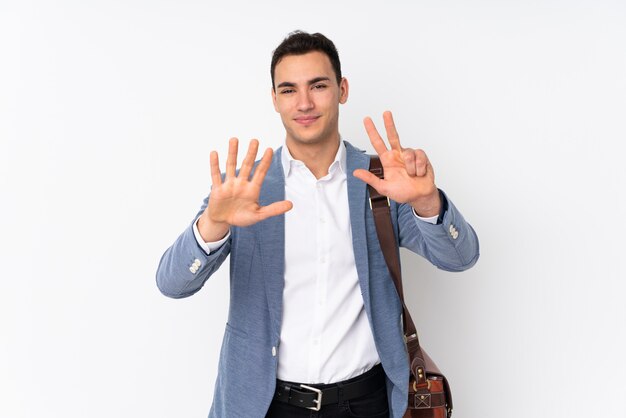 Young handsome businessman on wall counting eight with fingers