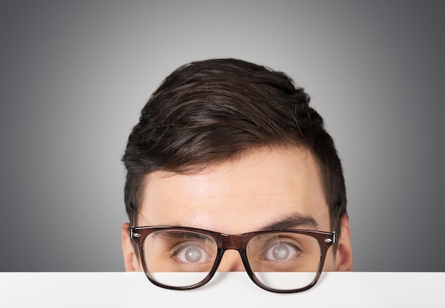 Young handsome businessman wearing glasses on blurred background