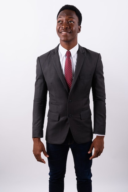 Young handsome businessman wearing suit against white