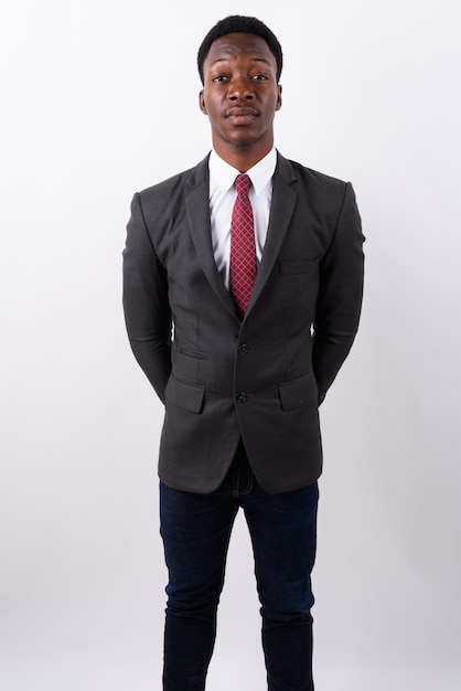 Young handsome businessman wearing suit against white