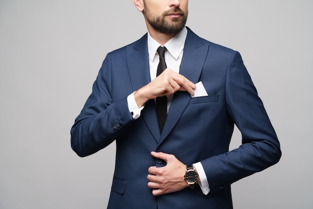 young handsome businessman wearing suit holding business card