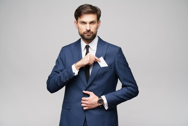 young handsome businessman wearing suit holding business card