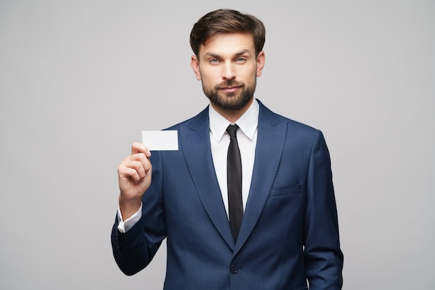 Photo young handsome businessman wearing suit holding business card