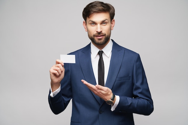 young handsome businessman wearing suit holding business card