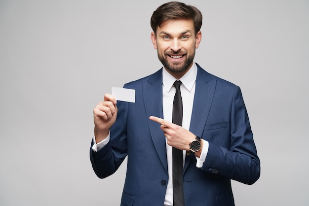 young handsome businessman wearing suit holding business card