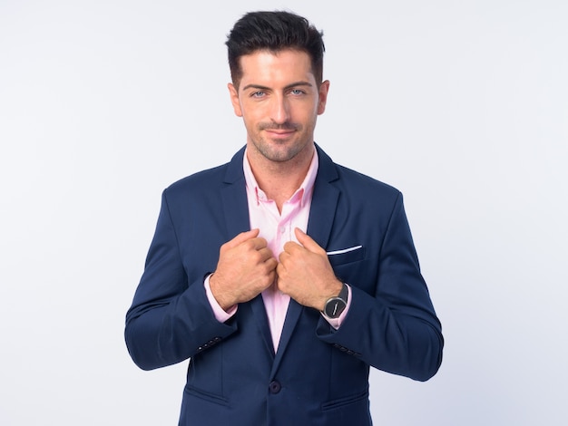  young handsome businessman wearing suit isolated against white wall