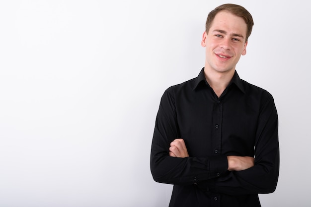 Young handsome businessman on white wall