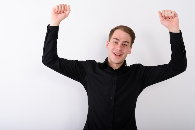 Young handsome businessman on white wall