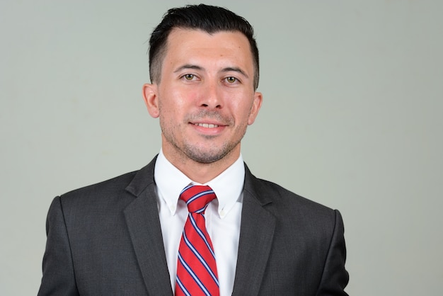 young handsome businessman with beard stubble in suit against white space