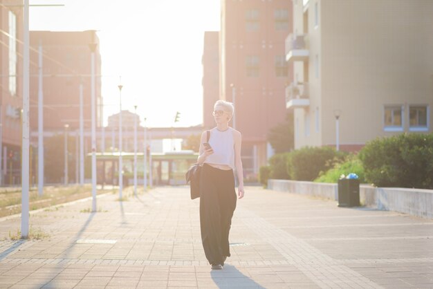 Young handsome caucasian blonde italian designer walking in the city backlight