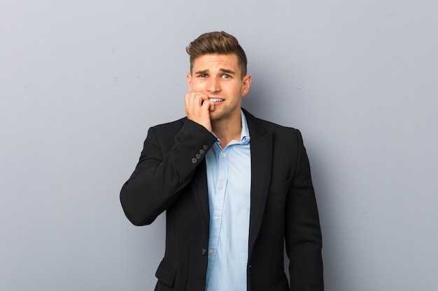 Young handsome caucasian man biting fingernails, nervous and very anxious.