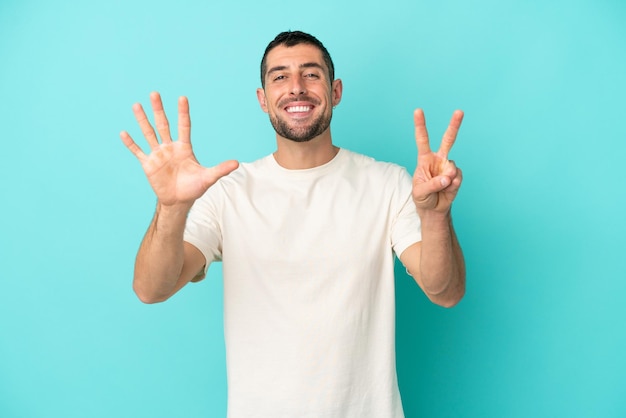 Young handsome caucasian man isolated on blue background counting seven with fingers