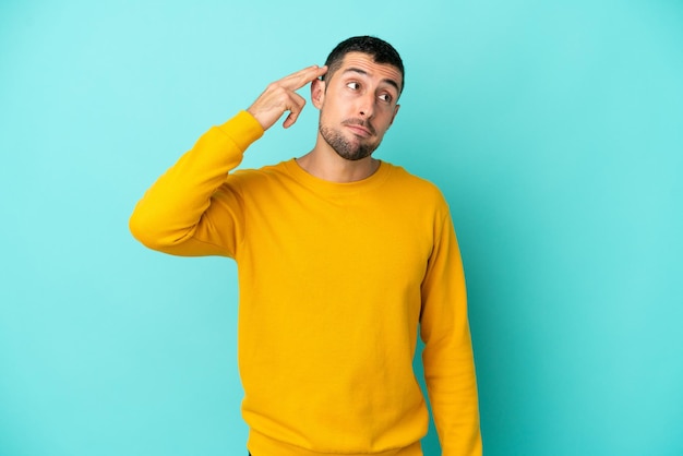 Young handsome caucasian man isolated on blue background with problems making suicide gesture