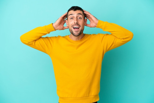 Young handsome caucasian man isolated on blue background with surprise expression