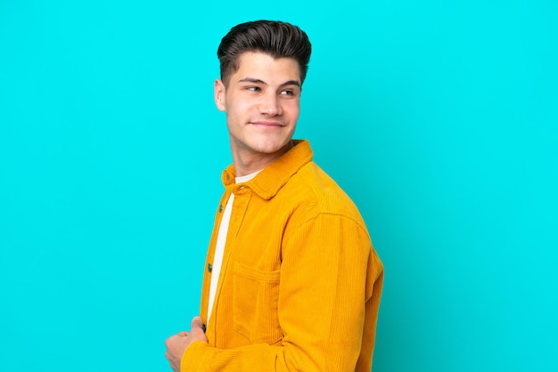 Young handsome caucasian man isolated on blue bakcground Portrait