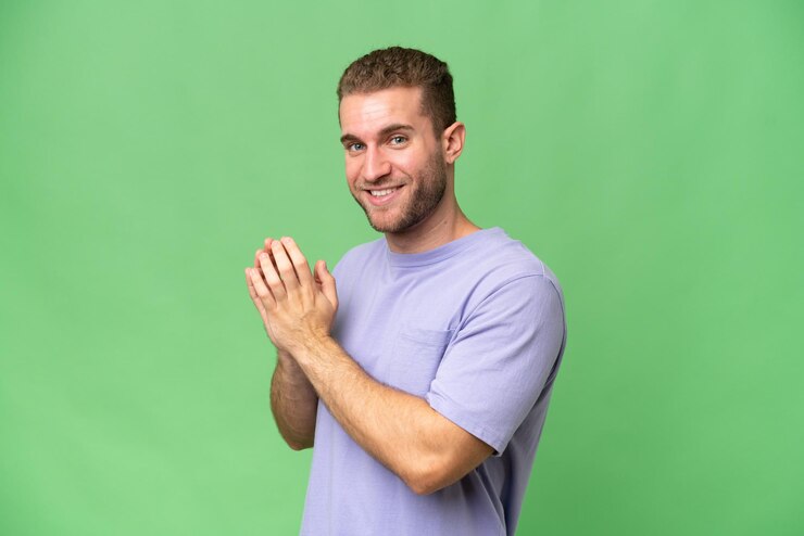 Photo young handsome caucasian man isolated on green chroma background scheming something