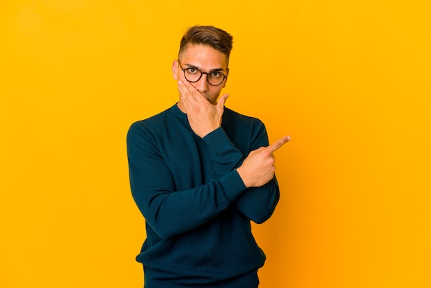 Young handsome caucasian man isolated pointing to the side