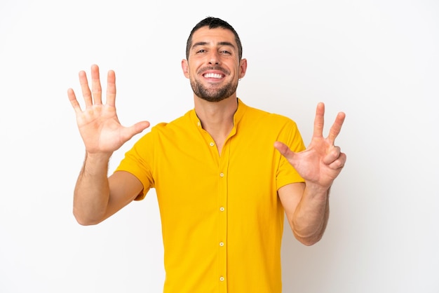 Giovane uomo caucasico bello isolato su sfondo bianco contando otto con le dita