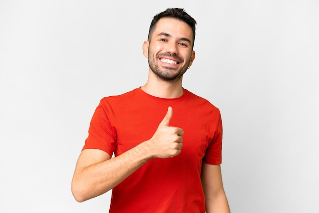 Young handsome caucasian man over isolated white background giving a thumbs up gesture