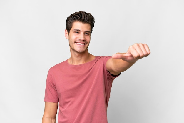 Young handsome caucasian man over isolated white background giving a thumbs up gesture