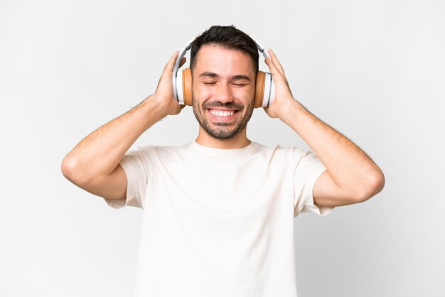 Young handsome caucasian man over isolated white background listening music