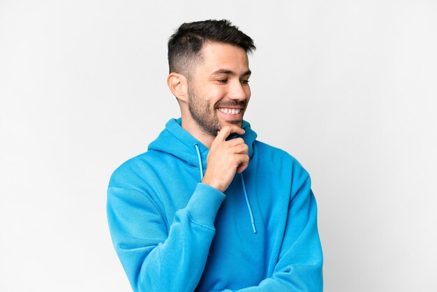 Young handsome caucasian man over isolated white background looking to the side and smiling