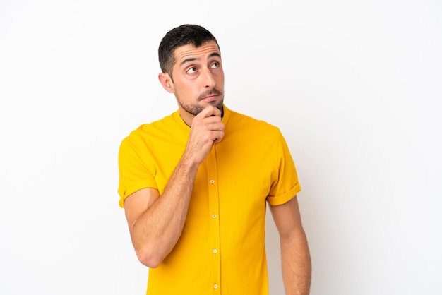 Young handsome caucasian man isolated on white background and looking up