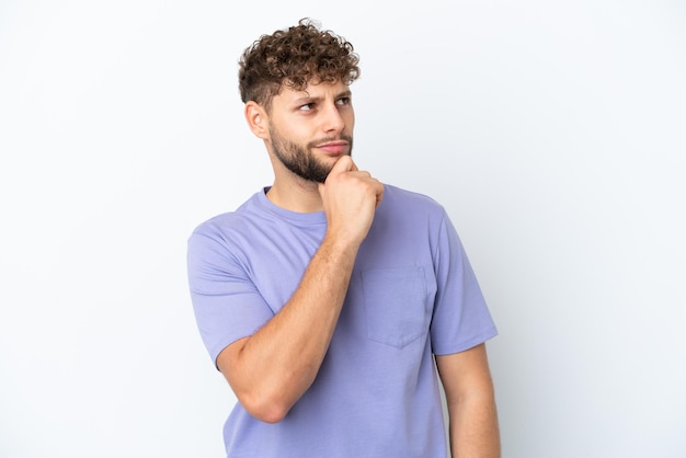 Young handsome caucasian man isolated on white background and looking up