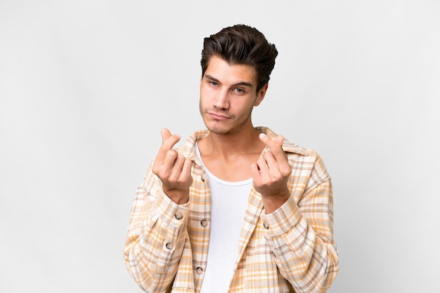 Young handsome caucasian man over isolated white background making money gesture but is ruined