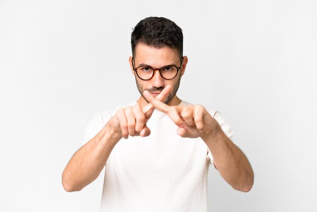 Young handsome caucasian man over isolated white background making stop gesture with her hand to stop an act